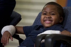 Double-hand transplant recipient eight-year-old Zion Harvey smiles during a news conference Tuesday, July 28, 2015, at The Childrens Hospital of Philadelphia (CHOP) in Philadelphia. Surgeons said Harvey of Baltimore who lost his limbs to a serious infection,  has become the youngest patient to receive a double-hand transplant. (AP Photo/Matt Rourke)