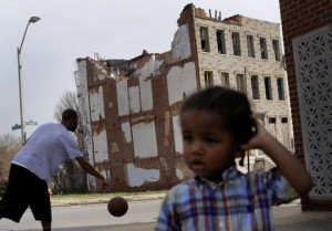 In this April 8, 2013 picture, a boy whose family asked that he not be identified plays across the street from a partially collapsed row house in Baltimore. The U.S. Census Bureau estimates that 20 percent of American children are impoverished. (AP Photo/Patrick Semansky)