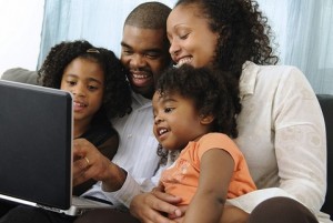 A happy family using a computer together.