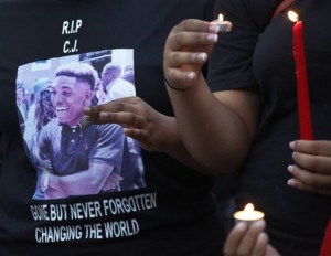 People participate in a candlelight vigil for Christian Taylor, held in the parking lot of Koinonia Christian Church in Arlington, Texas, Saturday, Aug. 8, 2015. The FBI has been asked to help investigate the death of Taylor, a Texas college football player, who was fatally shot by an officer during a burglary call at a car dealership, a suburban Dallas police chief said Saturday. (Louis DeLuca/The Dallas Morning News via AP) MANDATORY CREDIT; MAGS OUT; TV OUT; INTERNET USE BY AP MEMBERS ONLY; NO SALES