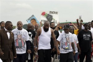 Michael Brown Sr., center, takes part in a parade in honor of his son, Michael Brown, Saturday, Aug. 8, 2015, in Ferguson, Mo. Sunday will mark one year since Michael Brown was shot and killed by Ferguson police officer Darren Wilson. (AP Photo/Jeff Roberson)