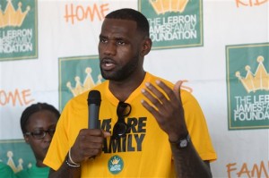 LeBron James speaks with reporters following the LeBron James Family Foundation "I Promise" reunion event Thursday, Aug, 13, 2015, at Cedar Point in Sandusky, Ohio. James is giving kids from Akron--ones with challenging backgrounds like his--the chance to go to college for free. The NBA star has partnered with the University of Akron to provide a guaranteed four-year scholarship to the school for students in James' "I Promise" program who qualify. The scholarship will cover tuition and the university's general service fee--currently $9,500 per year. (Robin Hecker/The Register via AP)