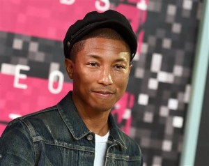 In this Aug. 30, 2015 file photo, Pharrell Williams arrives at the MTV Video Music Awards at the Microsoft Theater in Los Angeles. Pharrell has partnered with FirstBook, a nonprofit literacy organization, to donate up to 50,000 books to children in low-income families. Pharrells publisher, Penguin Young Readers, announced Tuesday, Sept. 29, that the Twitter hashtag #readHappy had been established for fans to post thoughts or images on why reading makes them Happy. Every post shared elsewhere on social media will lead to a donation.  Pharrells picture book Happy, based on his hit song, comes out next week.(Photo by Jordan Strauss/Invision/AP, File)