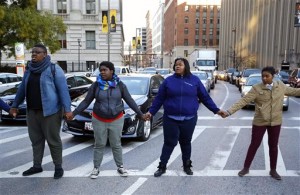 Protesters block traffic, Monday, Oct. 19, 2015, in Baltimore, after the City Council confirmed Kevin Davis as the city's permanent police commissioner. The council's vote came five days after a committee voted in favor of hiring Davis and demonstrators held a sit-in to demand meetings with Davis and Mayor Stephanie Rawlings-Blake. (AP Photo/Patrick Semansky)