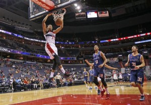 Washington Wizards forward Otto Porter Jr. (22) dunks the ball in front of Paschoalotto Bauru forwards Wesley Sena (12) and Robert Day (31) in the second half of a preseason NBA basketball game, Sunday, Oct. 11, 2015, in Washington. The Wizards won 134-100. (AP Photo/Alex Brandon)