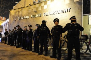 Chicago police officers line up outside the District 1 central headquarters at 17th and State streets, Tuesday, Nov. 24, 2015, in Chicago, during a protest for 17-year-old Laquan McDonald, who was fatally shot and killed in October 2014. Chicago police Officer Jason Van Dyke was charged Tuesday with first-degree murder in the killing. (AP Photo/Paul Beaty)
