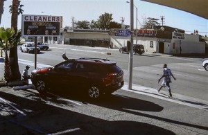 In this image made from security video footage provided by the Los Angeles County Sheriff, a man, right, walks with a gun in his hand Saturday, Dec. 12, 2015 in Lynwood, Calif. Two deputies fired 33 bullets at the man after he refused to drop the gun and walked across a busy street to a filling station where a family was pumping gas, homicide Cpt. Steven Katz said. He died at the scene Saturday morning. Authorities released the video Sunday in response to questions about why they continued to fire on the man after he fell to the pavement. (Los Angeles County Sheriff via AP)