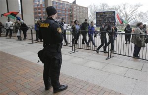 A Sheriff's deputy watches as people march outside the Cuyahoga County Justice Center, Tuesday, Dec. 29, 2015, in Cleveland. People marched peacefully in front of the Justice Center in downtown Cleveland to protest a grand jury's decision not to indict two white Cleveland police officers in the fatal shooting of Tamir Rice, a black 12-year-old boy who was playing with a pellet gun.(AP Photo/Tony Dejak)