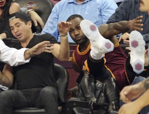 Cleveland Cavaliers' LeBron James falls into Ellie Day, wife of PGA Tour golf player Jason Day, at left, during the second half of an NBA basketball game against the Oklahoma City Thunder, Thursday, Dec. 17, 2015, in Cleveland. (John Kuntz/The Plain Dealer via AP) MANDATORY CREDIT; NO SALES