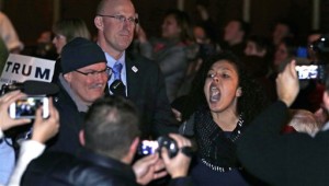 A protestor yells as she is escorted by security out of the audience during an address by Republican presidential candidate Donald Trump at a campaign stop at the Flynn Center of the Performing Arts in Burlington, Vt., Thursday, Jan. 7, 2016. (AP Photo/Charles Krupa)