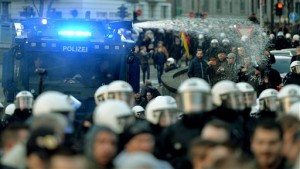 Police  drive back right-wing demonstrators using a water cannon during protests in Cologne, Germany, Saturday Jan. 9, 2016.  Womens rights activists, far-right demonstrators and left-wing counter-protesters all took to the streets of Cologne on Saturday in the aftermath of a string of New Years Eve sexual assaults and robberies in Cologne blamed largely on foreigners..  (Monika Skolimowska/dpa via AP)