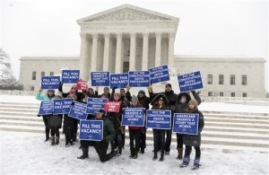 A group with "People for the American Way" from Washington, gather with signs in front of the U.S. Supreme Court in Washington, Monday, Feb. 15, 2016, as they are call for Congress to give fair consideration to any nomination put forth by President Barack Obama to fill the seat of Antonin Scalia. Scalia, the influential conservative and most provocative member of the Supreme Court, was found dead over the weekend at a private residence in the Big Bend area of West Texas. He was 79. (AP Photo/Carolyn Kaster)