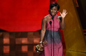 In this Sunday, Sept. 20, 2015 file photo, Uzo Aduba accepts the award for outstanding supporting actress in a drama series for "Orange Is The New Black" at the 67th Primetime Emmy Awards at the Microsoft Theater in Los Angeles. In one of the exhaustive and damning reports on diversity in Hollywood, a new study finds that the films and television produced by major media companies are whitewashed, and that an epidemic of invisibility runs top to bottom through the industry for women, minorities and LGBT people. A study to be released Monday, Feb. 22, 2016, by the Media, Diversity and Social Change Initiative at the University of Southern Californias Annenberg School for Communication and Journalism offers one of the most wide-ranging examinations of the film and television industries, including a pointed inclusivity index of 10 major media companies - from Disney to Netflix - that gives a failing grade to every movie studio and most TV makers. (Photo by Chris Pizzello/Invision/AP, File)