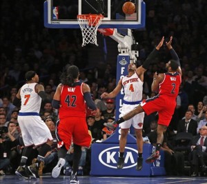 Washington Wizards guard John Wall (2) shoots as New York Knicks guard Arron Afflalo (4) defends with New York Knicks forward Carmelo Anthony (7) and Washington Wizards center Nene Hilario (42) watching from the floor, in the second half of an NBA basketball game at Madison Square Garden in New York, Tuesday, Feb. 9, 2016. The Wizards defeated the Knicks 111-108. (AP Photo/Kathy Willens)