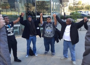 Activists hold hands and pray outside outside Los Angeles Police Department headquarters following the police commission's decision finding that the shooting of Charly "Africa" Keunang was justified in Los Angeles on Tuesday, Feb. 2, 2016. The Los Angeles Police Commission civilian oversight panel found that one Los Angeles police officers were justified in the fatal shooting of a homeless black man in Skid Row. Police Chief Charlie Beck has said the shooting was justified because Keunang grabbed for a rookie police officer's gun after ignoring commands and becoming combative. He said the officer's gun was later found partly cocked and jammed with one round of ammunition in the chamber and another in the ejection port, indicating a struggle for the weapon. (AP Photo/Amanda Lee Myers)