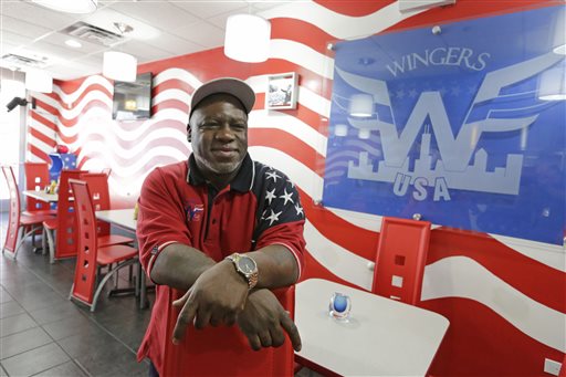 In this Thursday, Feb. 4, 2016 photo, Eric Caine poses in his restaurant, "Wingers USA" in Chicago. Caine was falsely imprisoned at the age of 20, but later freed at 46 for a double murder he didn't commit. He received a $10 million settlement from the city of Chicago. Chicago has racked up a $662 million bill to settle police misconduct cases since 2004, but few officers have been punished. (AP Photo/M. Spencer Green)