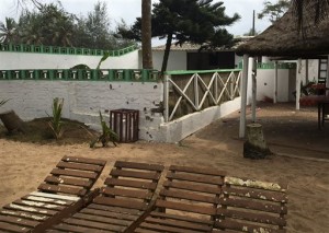 Bullet holes are seen on a wall, center, outside of the Nouvelle Paillote hotel, one of the three hotels involved in an attack at Grand Bassam, Ivory Coast, Monday, March 14, 2016. Survivors of the first attack by Islamic extremists in Ivory Coast described scenes of confusion and fear as the jihadists gunned down defenseless civilians at a beachfront resort area. (AP Photo/Christin Roby)