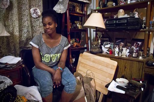 FILE - In this May 22, 2015 file photo, Candie Hailey, 32, sits in the small living room of her father's apartment in the Bronx borough of New York, as she talks about her incarceration at the Riker's Island jail. Hailey will stand trial Monday, March 21, 2016, for criminal charges stemming from a jailhouse confrontation with guards. If convicted she faces up to seven years in prison. (AP Photo/Bebeto Matthews, File)