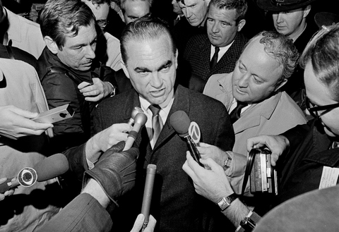 FILE - In this Oct. 29, 1968 file photo, reporters surround presidential candidate, former Alabama Gov. George Wallace at Metro Airport in Detroit, Mich., after the presidential candidate arrived to address a night rally at Cobo Hall. Donald Trump promises to “Make America Great Again.” George Wallace said he would “Stand up for America.” The 2016 Republican presidential front-runner doesn’t say he’s following the 1960s playbook of the Alabama segregationist, a four-time presidential hopeful. (AP Photo/Preston Stroup)