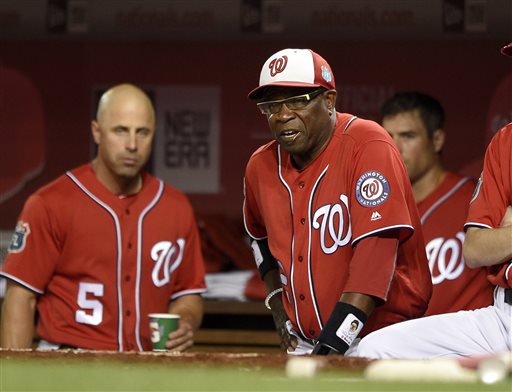 Washington Nationals manager Dusty Baker, right, looks on during the seventh inning of an interleague exhibition baseball game against the Minnesota Twins, Friday, April 1, 2016, in Washington. The Nationals won 4-3. Also seen is Washington Nationals' Reed Johnson (5). (AP Photo/Nick Wass)