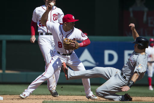 Miami Marlins J.T. Realmuto, right, slides into second base as Washington Nationals shortstop Danny Espinosa turns a double play during the fifth inning of a baseball game at Nationals Park, Sunday, April 10, 2016, in Washington. (AP Photo/Evan Vucci)