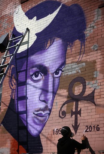 Artist Rock Martinez continues work on a mural he is painting of musician Prince in Minneapolis, Saturday, April 23, 2016. The pop superstar died Thursday at the age of 57. (Jim Gehrz /Star Tribune via AP)  MANDATORY CREDIT; ST. PAUL PIONEER PRESS OUT; MAGS OUT; TWIN CITIES LOCAL TELEVISION OUT