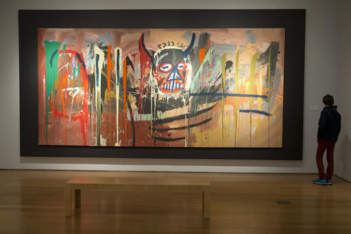 In this April 29, 2016, file photo, a visitor inspects "Untitled" by Jean-Michel Basquiat on display during the press preview of "Bound to Fail" at Christie's auction house in New York. A large blue and green painting by Mark Rothko and the monumental self-portrait by Jean-Michel Basquiat are among the major highlights of Christie's contemporary art sale Tuesday, May 10. (AP Photo/Mary Altaffer, File)