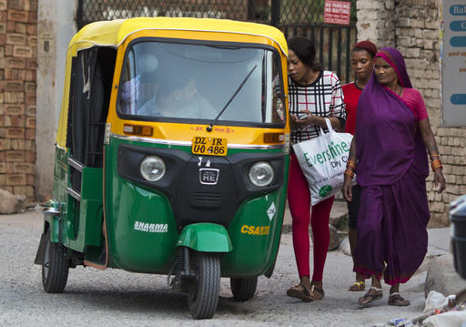 In this photo made on June 8, 2016, African women negotiate the price of a three wheeler taxi ride in New Delhi, India. For hundreds of thousands of Africans drawn to India by better education and work opportunities, rampant racism is a daily battle. In a country where fair skin is prized, their dark skin places them at the lower end of a series of strictly observed social hierarchies. (AP Photo/Saurabh Das)