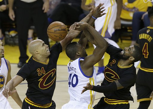 Golden State Warriors forward Harrison Barnes, center, loses the ball as he shoots between Cleveland Cavaliers forward Richard Jefferson (24) and guard Kyrie Irving during the first half of Game 5 of basketball's NBA Finals in Oakland, Calif., Monday, June 13, 2016. (AP Photo/Marcio Jose Sanchez)